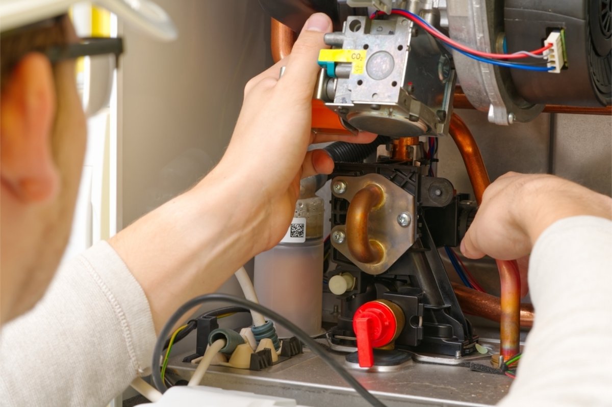 Technician testing electrical components with a digital multimeter.