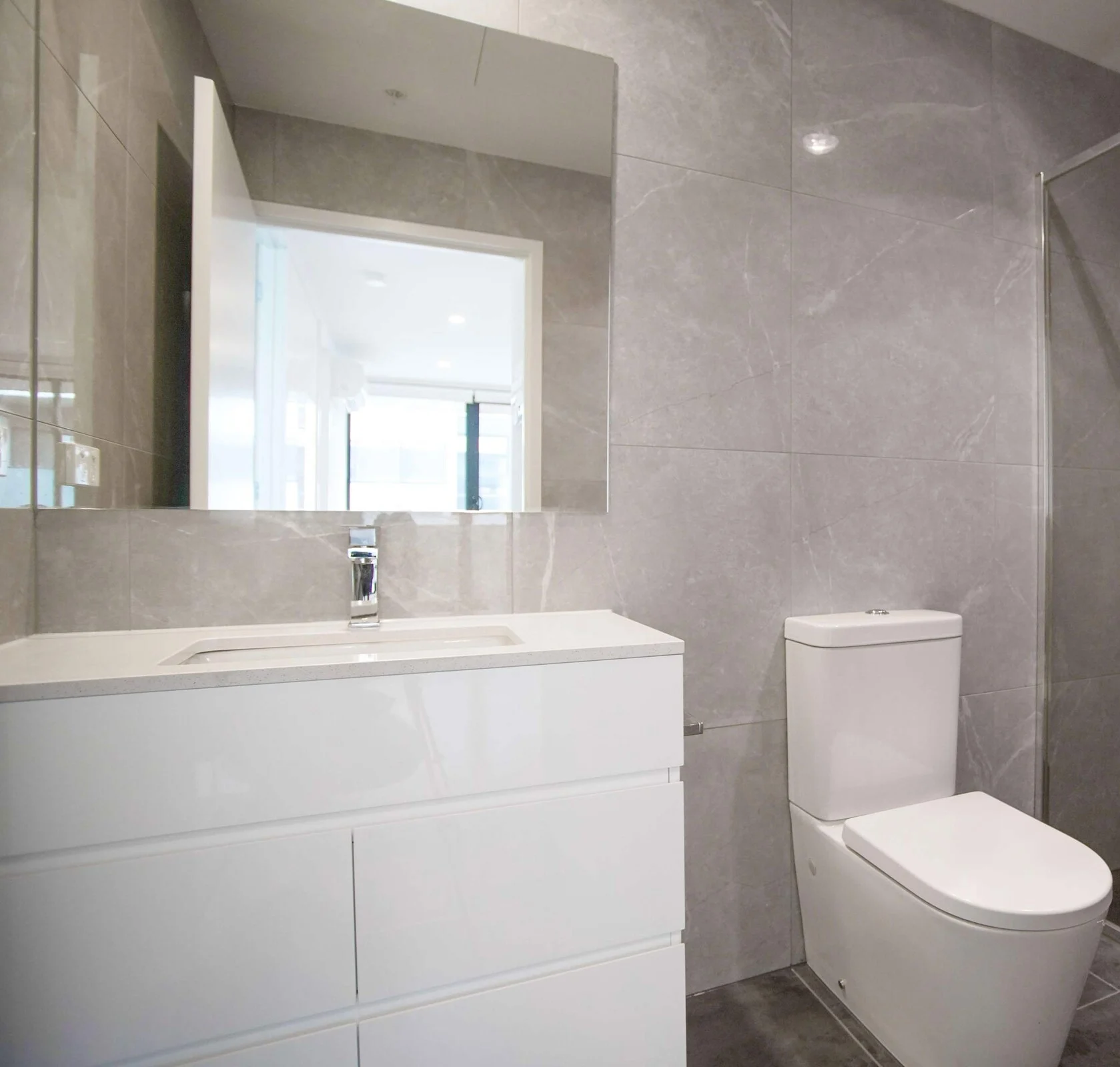 Expansive luxury walk-in shower with premium tiling and chrome showerheads.